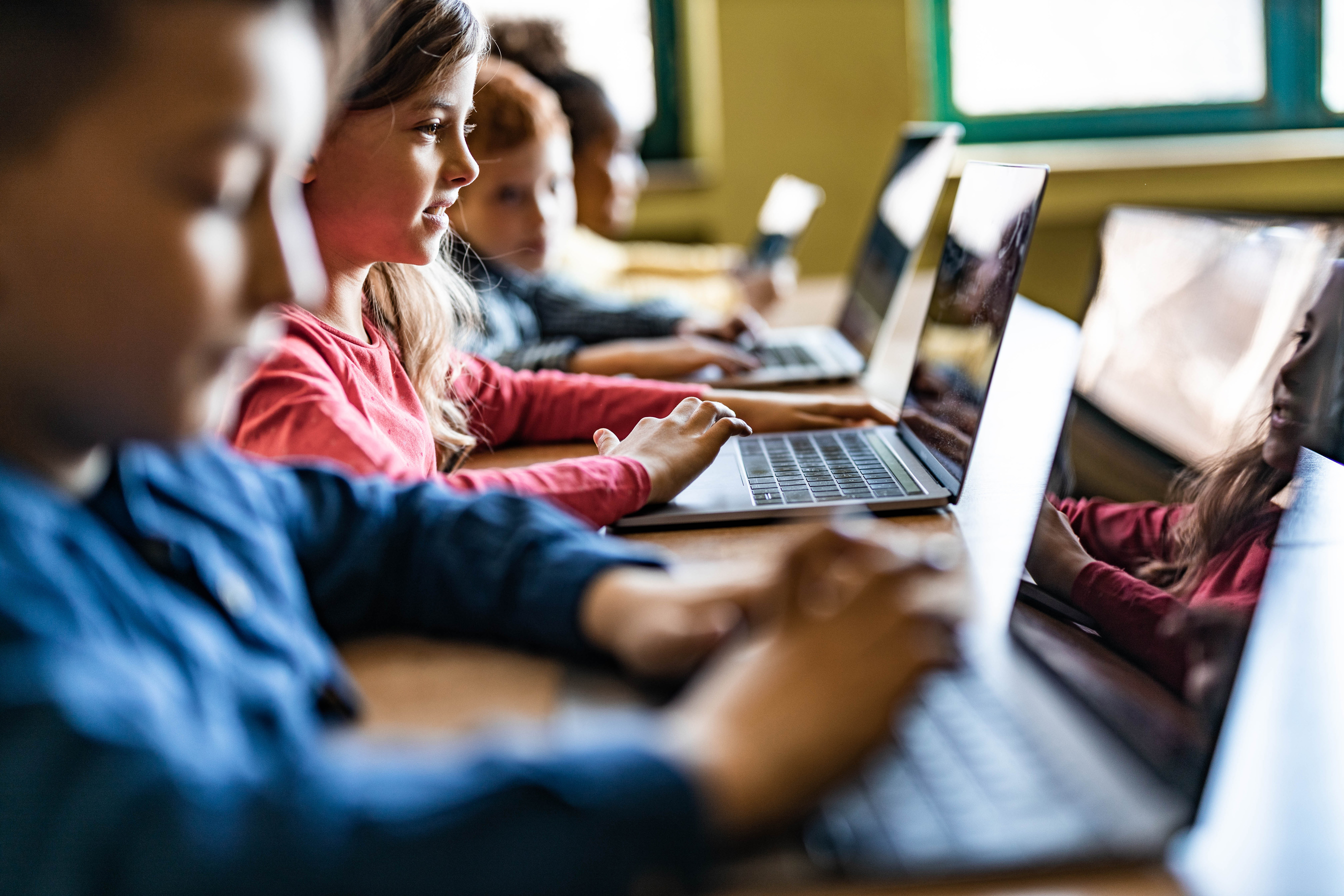 Digital native students e-learning over computers at school.